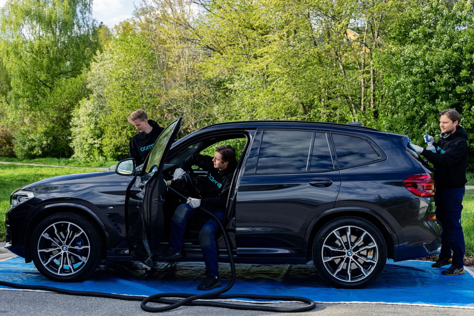 Carmee tvättar en bil på plats hos kunden